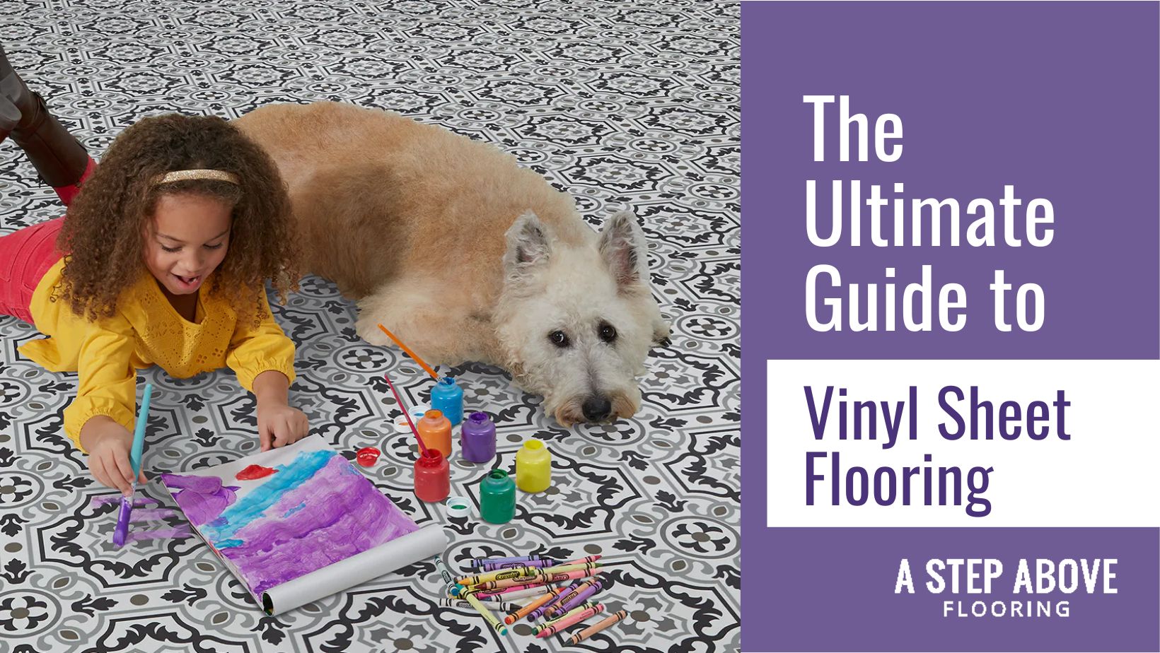 A little girl painting a picture while laying on the floor next to a dog